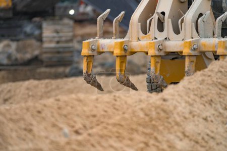 Photo for Rear scarifier tines of a grader working in sand - Royalty Free Image