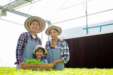 Photo for Thai Asian farmer family smiling in hydroponic vegetable farm. - Royalty Free Image