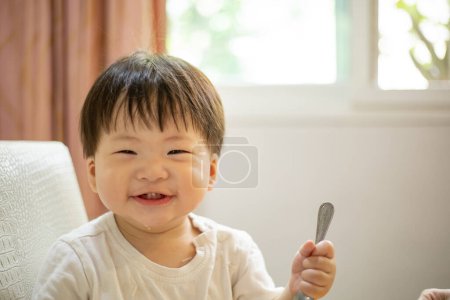 Photo for Asian baby boy smile after have lunch in kitchen room. - Royalty Free Image