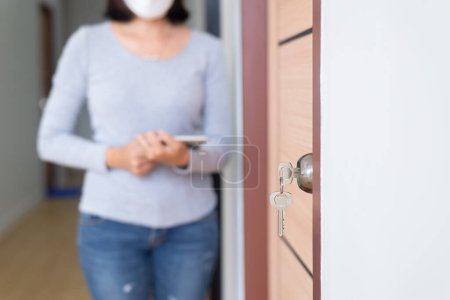 Photo for Modern doornkop and key with blurred woman inspector at new house,Door knob locks with keys - Royalty Free Image