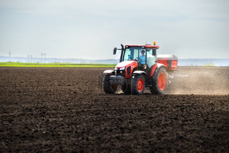 Tractor de propagación de fertilizantes artificiales en el campo
