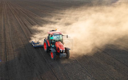 Exploitation de labour de tracteurs préparant le sol pour la plantation de nouvelles cultures pendant la soirée.