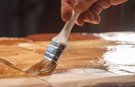 Foto de Tinción de madera Primer plano. El primer plano de la mano aplicando la mancha a la madera - Imagen libre de derechos
