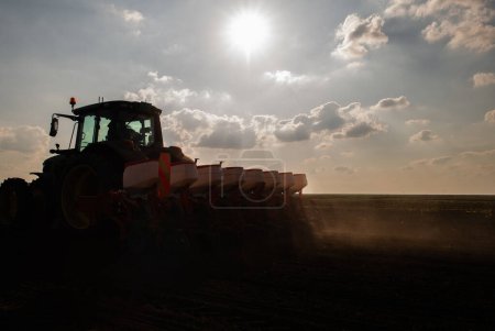 Foto de Agricultor con siembra de tractores - siembra de cultivos en el campo agrícola. Plantas, trigo. - Imagen libre de derechos