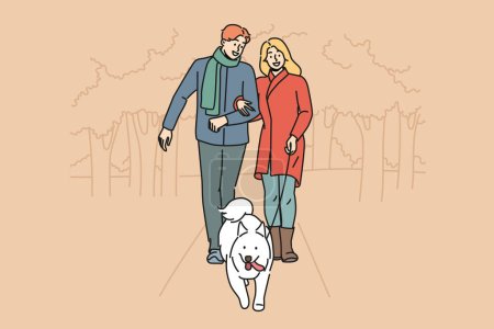 Mann und Frau gehen gemeinsam mit ihrem Hund im Park spazieren und genießen den Herbstabend bei warmem Wetter. Glückliches Paar mit weißem Hund an der Leine kümmert sich um Haustier, das rechtzeitig im Freien spazieren geht
