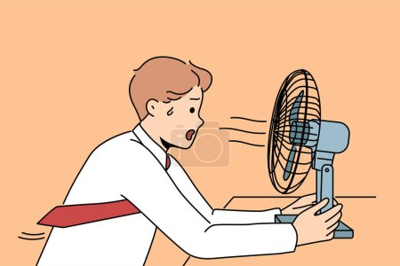 Illustration for Sweaty man sits in front of fan enjoying cold wind from electric climate control equipment. Young businessman with fan suffers from lack of air conditioning and ventilation in office - Royalty Free Image