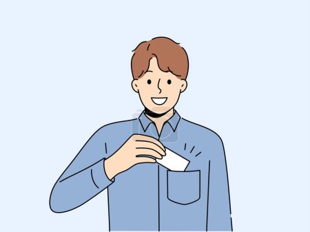 Man takes out business card from pocket to exchange contacts with potential partner or buyer and looks into camera with smile. Business guy in blue shirt wants to share contacts with new acquaintances