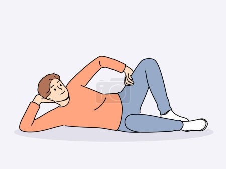 Man lies on floor with hand under head and with smile looks at screen, offering to relax and unwind. Happy guy lies on ground and smiles, feeling lazy orlacking initiative for personal growth.