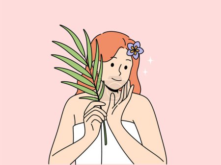 Woman with sprig of medicinal plant used for cosmetic purposes, stands in bath towel and rejoices at effect of using cream. Woman recommends using eco-masks and creams based on organic herbs