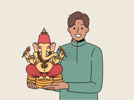 Der indische Mann hält eine Figur von Lord Ganesha in der Hand und lächelt und demonstriert ein nationales Amulett, das Glück und Erfolg bringt. Lord Ganesha aus Keramik in den Händen Kerl einladend zum Festival der Hindi-Kultur