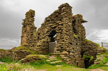 Foto de Ruinas de un castillo Sinclair Girnigoe en Escocia. Hermosa estructura de piedra construida sobre una aleta de roca. Clima nublado. - Imagen libre de derechos