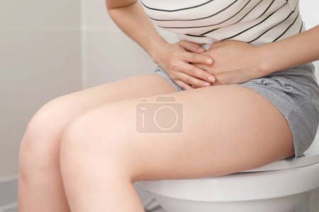 Una mujer diarrea excretando en el baño en casa
