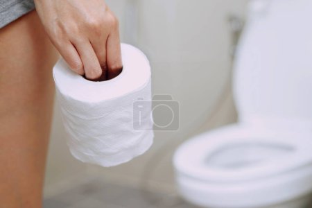 Téléchargez les photos : Une femme diarrhée excrétant dans la salle de bain à la maison - en image libre de droit