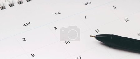 Photo for Calendar month schedule to make appointment meeting or manage timetable each day lay and pen on wooden background for planning work and travel concept. banner copy space. - Royalty Free Image