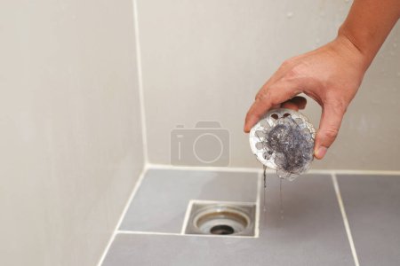 Foto de Tubo obstruido, colador anti-olor con basura maloliente en el baño - Imagen libre de derechos