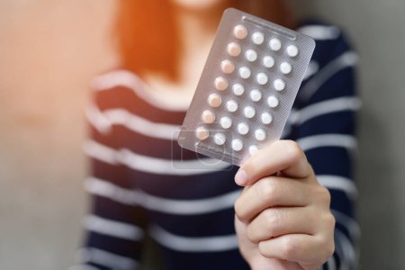 Frau hält Tabletten zur Geburtenkontrolle in der Hand. Antibabypille essen. Verhütung reduziert Geburts- und Schwangerschaftskonzept.