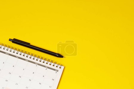 Téléchargez les photos : Calendrier du mois civil pour prendre rendez-vous réunion ou gérer l'horaire chaque jour pose et stylo sur fond jaune pour planifier le travail et le concept de voyage. - en image libre de droit