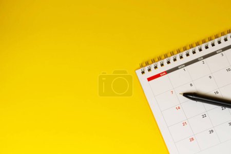 Téléchargez les photos : Calendrier du mois civil pour prendre rendez-vous réunion ou gérer l'horaire chaque jour pose et stylo sur fond jaune pour planifier le travail et le concept de voyage. - en image libre de droit