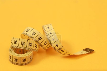 tape measure for obese people on a yellow background soft focus