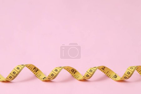 tape measure for obese people on a pink background soft focus
