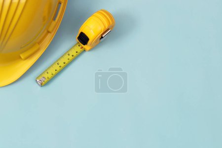 Téléchargez les photos : Le ruban à mesurer jaune pour le maçon est placé sur un fond bleu. Concentration douce. - en image libre de droit
