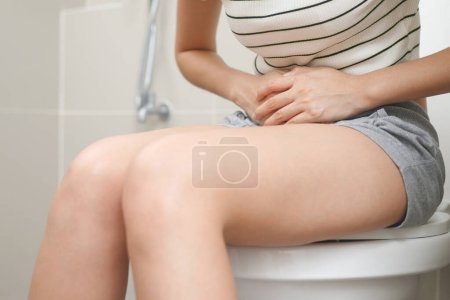 Eine Frau mit Durchfall, die zu Hause im Badezimmer ausscheidet