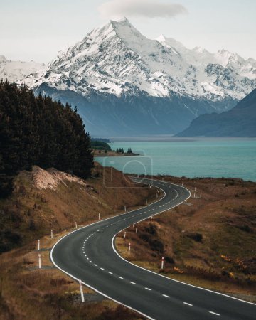 Téléchargez les photos : Route sinueuse panoramique le long du lac Pukaki jusqu'au parc national du Mont Cook, île du Sud, Nouvelle-Zélande pendant la matinée froide et venteuse d'hiver. L'un des plus beaux points de vue de Aoraki Mount Cook. Photographie - en image libre de droit