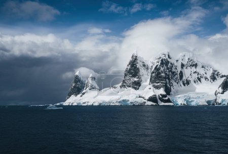 Landscape of snowy mountains and icy shores of the Lemaire Channel in the Antarctic Peninsula, Antarctica. Global warming and climate change concept. Photo taken in Antarctica.