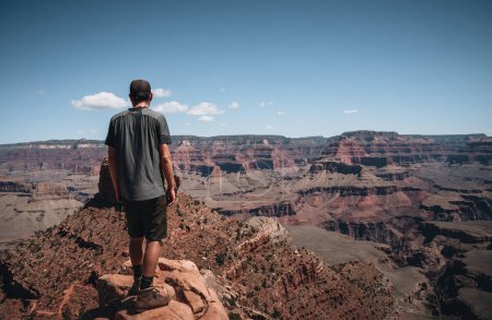 Téléchargez les photos : Jeune homme trousiste debout devant le Grand Canyon. Randonneur avec sac à dos bénéficiant d'une vue, États-Unis. Concept de voyage et plein air. Parcs nationaux États-Unis. Photo prise aux États-Unis. - en image libre de droit