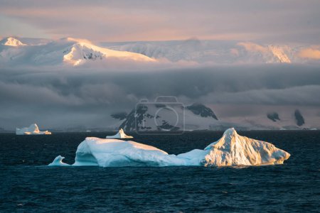 Photo for Antarctic Iceberg nature landscape during midnight sun sunset sunrise in the horizon. Early morning summer alpenglow during near arctiv circle. Concept of Climate Change and Global warming. Photo - Royalty Free Image