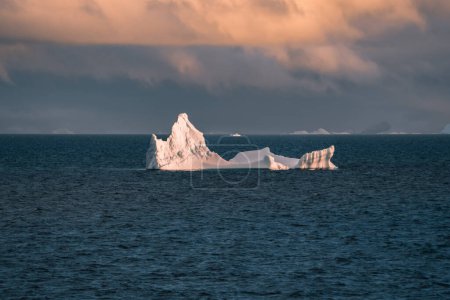 Téléchargez les photos : Antarctique iceberg paysage naturel pendant minuit coucher de soleil lever du soleil à l'horizon. Alpenglow d'été tôt le matin pendant près du cercle arctiv. Concept de changement climatique et de réchauffement climatique. Photographie - en image libre de droit