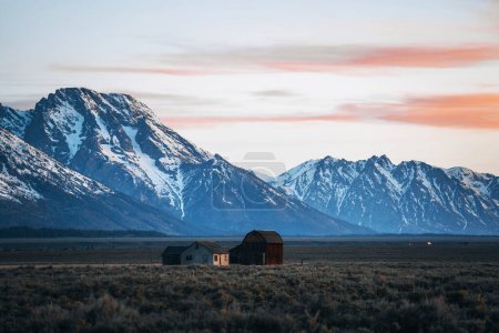 Téléchargez les photos : Une grange pionnière mormone américaine sur Mormon Row dans le parc national Grand Teton au lever du soleil. Wyoming, États-Unis - en image libre de droit