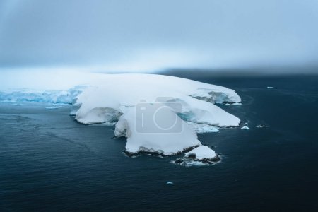 Photo for A floating iceberg in the antarctic peninsula, antarctica and arctic greenland. Global warming and Climate chance concept. Iceberg with hole. Photo taken in Antarctica. - Royalty Free Image