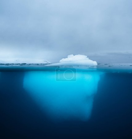 Photo for Split view of an iceberg showing above and below the water line. Underwater iceberg. Antarctica. Arctic Greenland. Climate change and global warming travel concept - Royalty Free Image