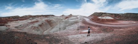 Photo for Bentonite hills Amazing aerial view. Two tourists looking at camera. Located in Capitol Reef National Park, United States, Utah - Royalty Free Image