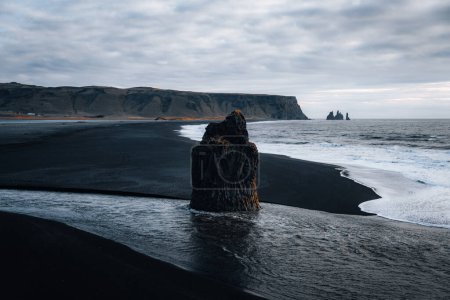 Arnardrangur rock in the middle of peninsula near Reynisfjara Beach view point Dyrholaey with moody sea scape and waves. South iceland