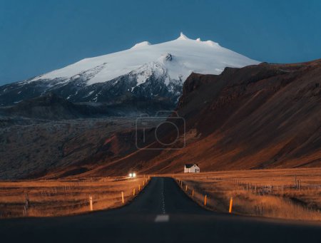 Ruhige Straße zu einem riesigen Vulkanberg in der Ferne, in der Nähe des Snaefellsjokull Nationalparks, Island