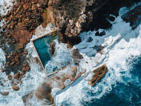 Foto de Vista aérea a primera hora de la mañana con olas oceánicas que fluyen sobre rocas alrededor de la piscina de rocas North Curl Curl Ocean durante la tormenta. Foto tomada en Australia. - Imagen libre de derechos