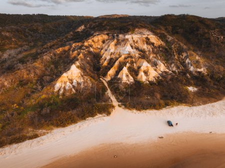 Foto de Vista aérea del dron de los pináculos, arenas de colores en la isla Fraser, salida del sol con el coche. Kgari, Queensland, Australia - Imagen libre de derechos