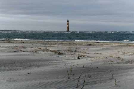 Sand and sea grasses on Folly Beach near Morris Island Lighthouse in Charleston, South Carolina.
