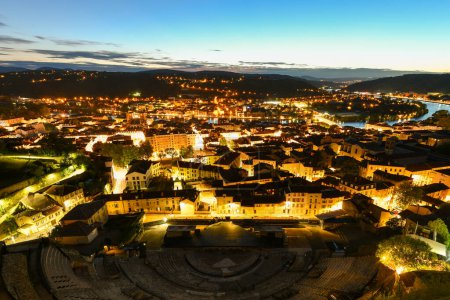 Photo for Vienne Roman Theatre in the foreground and the city of Vienne in the background at night. First century AD theatre in France. - Royalty Free Image