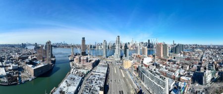 Luftaufnahme des Long Island City Bahnhofs in Queens, New York mit der Skyline von Manhattan im Hintergrund.