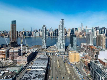 Luftaufnahme des Long Island City Bahnhofs in Queens, New York mit der Skyline von Manhattan im Hintergrund.