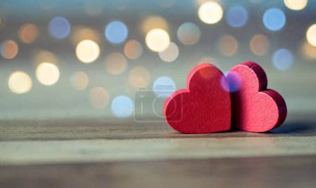 Téléchargez les photos : Deux cœurs rouges en bois sur table en bois rustique avec bokeh léger, le concept d'amour et de couple. Concept de Saint-Valentin - en image libre de droit