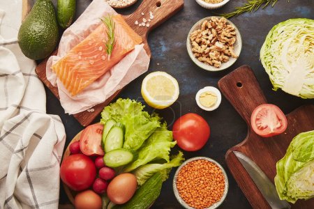  Estética saludable bajo forraje alimentos-verduras, frutas, nueces, salmón ahumado, verduras, aguacate. Vista superior.