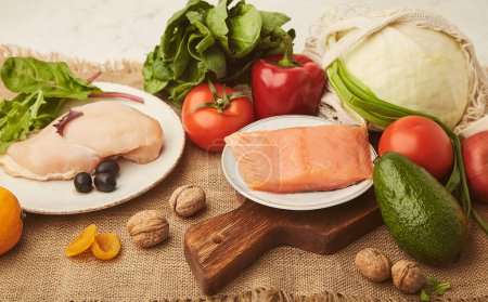Menú para baja en carbohidratos, dieta FODMAP con verduras, frutas, filete de pollo, salmón ahumado, verduras, nueces, aceitunas. Estilo de vida saludable.