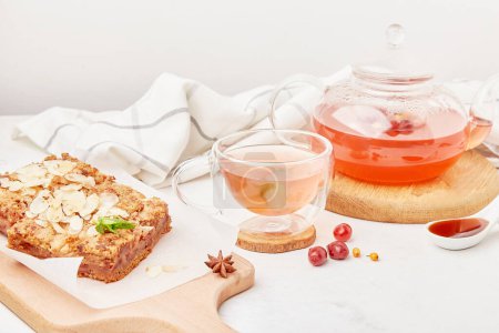 Tarta de canela casera con tetera de vidrio y taza de bebida de arándano rojo - ajuste de mesa estético otoño