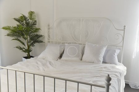 Foto de Interior sereno y espacioso dormitorio con acento verde fresco. Dormitorio minimalista moderno con sábanas blancas - Imagen libre de derechos