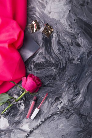 Téléchargez les photos : Outils de maquillage glamour et rose fraîche sur fond d'art fluide monochrome. - en image libre de droit