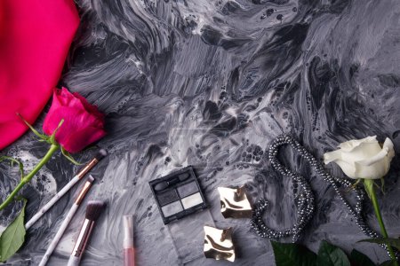 Téléchargez les photos : Ensemble cosmétique élégant avec roses roses et blanches sur peinture abstraite dynamique. - en image libre de droit